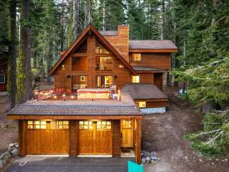 Nestled amidst towering pine trees, this stunning wooden A-frame cabin offers a luxurious mountain retreat.