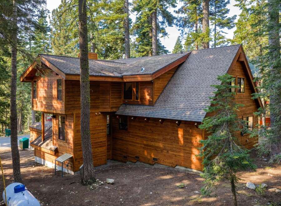 Nestled amidst tall pine trees, this charming wooden cabin offers a serene mountain retreat.