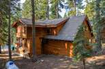 Nestled amidst tall pine trees, this charming wooden cabin offers a serene mountain retreat.