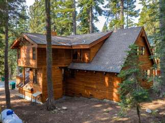 Nestled amidst tall pine trees, this charming wooden cabin offers a serene mountain retreat.