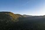 Experience breathtaking mountain vistas from this stunning property, nestled amidst a dense forest of evergreen trees.