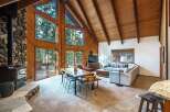 Experience rustic charm in this stunning mountain retreat, featuring a grand stone fireplace and soaring vaulted ceilings with exposed wooden beams.
