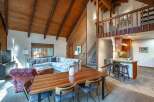 Experience rustic charm in this spacious living area featuring a vaulted wood-paneled ceiling and a large sectional sofa perfect for gatherings.