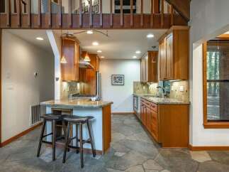 This charming kitchen boasts warm wooden cabinetry and granite countertops, creating a cozy and inviting atmosphere.