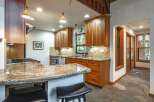 This spacious kitchen boasts beautiful granite countertops and warm, custom wood cabinetry, offering ample storage and a luxurious feel.