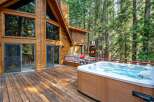 Experience ultimate relaxation in this stunning mountain retreat, featuring a spacious wooden deck with a luxurious hot tub and a gas grill, perfect for entertaining.