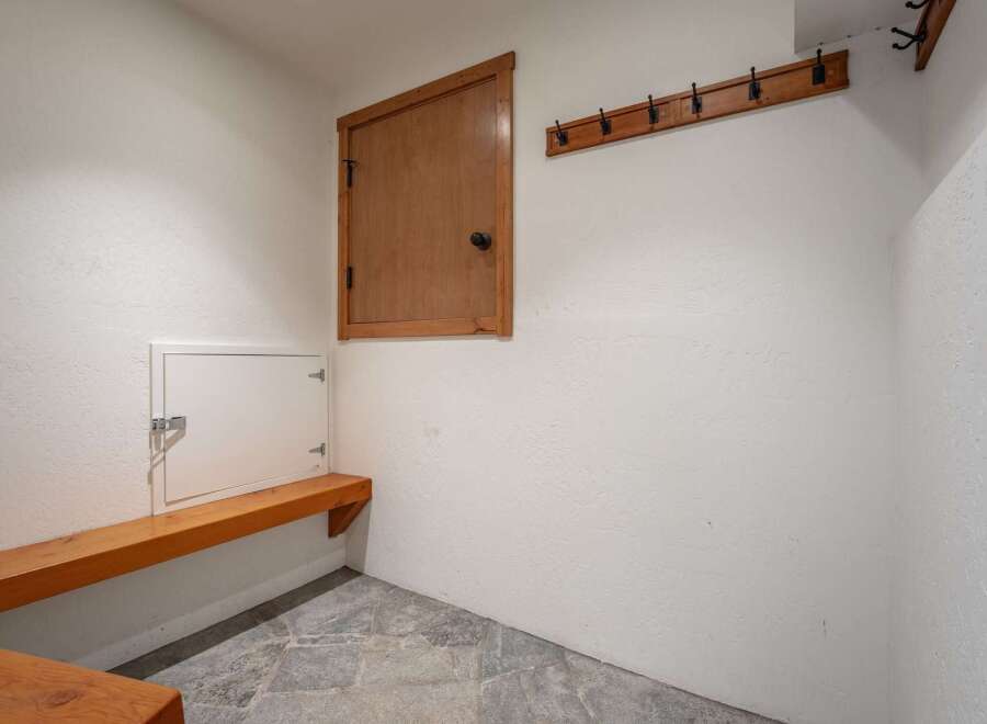 This functional mudroom features a built-in wooden bench perfect for putting on or taking off shoes.