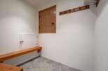 This functional mudroom features a built-in wooden bench perfect for putting on or taking off shoes.