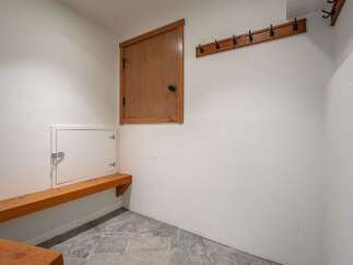 This functional mudroom features a built-in wooden bench perfect for putting on or taking off shoes.