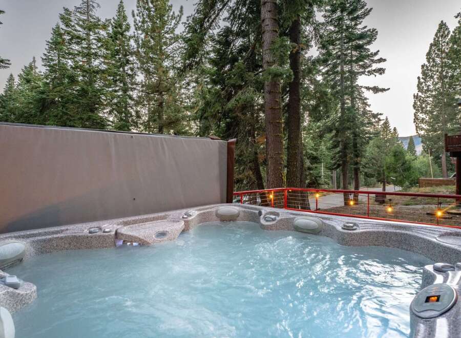 Indulge in ultimate relaxation in this luxurious hot tub, perfectly situated amidst a serene forest setting.