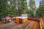 Experience ultimate relaxation on this spacious wooden deck, featuring a luxurious hot tub perfect for unwinding amidst the serene forest.