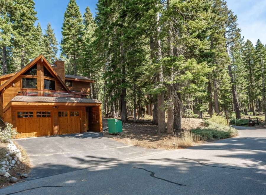Nestled amidst towering pine trees, this stunning wooden A-frame home offers a serene mountain retreat.