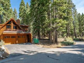 Nestled amidst towering pine trees, this stunning wooden A-frame home offers a serene mountain retreat.