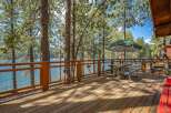 Enjoy breathtaking lake views from this expansive wooden deck, perfect for outdoor dining and relaxation.