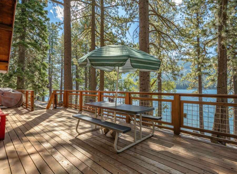 Enjoy breathtaking lake views from this spacious wooden deck, perfect for outdoor dining and relaxation.