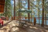 Enjoy breathtaking lake views from this spacious wooden deck, perfect for outdoor dining and relaxation.