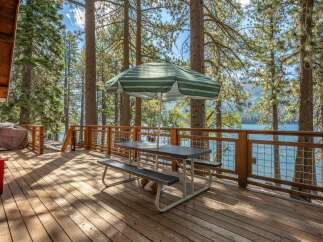 Enjoy breathtaking lake views from this spacious wooden deck, perfect for outdoor dining and relaxation.