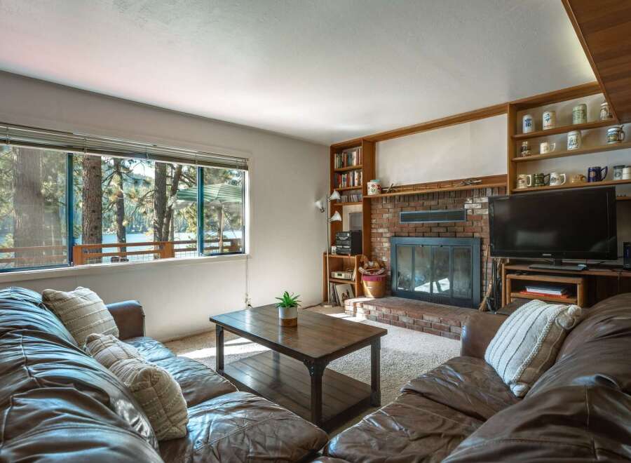 Experience breathtaking lake views from this cozy living room, featuring a large picture window that floods the space with natural light.