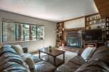 Experience breathtaking lake views from this cozy living room, featuring a large picture window that floods the space with natural light.