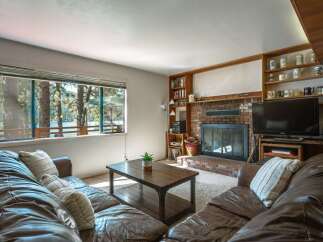 Experience breathtaking lake views from this cozy living room, featuring a large picture window that floods the space with natural light.