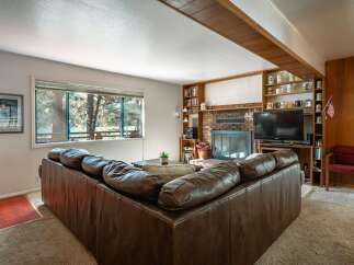 Cozy up by the brick fireplace in this inviting living room, featuring a spacious sectional sofa perfect for family gatherings.