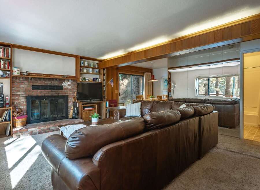 Cozy living room featuring a large brick fireplace and built-in bookshelves, perfect for relaxing evenings.