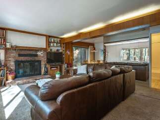 Cozy living room featuring a large brick fireplace and built-in bookshelves, perfect for relaxing evenings.