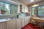 Enjoy breathtaking lake and mountain views from this charming kitchen, featuring a double sink and ample cabinet space.