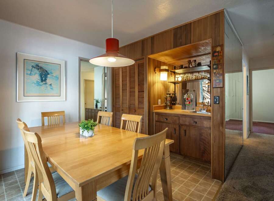 This dining area features a light wood table with four chairs, perfect for intimate meals.