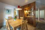 This dining area features a light wood table with four chairs, perfect for intimate meals.
