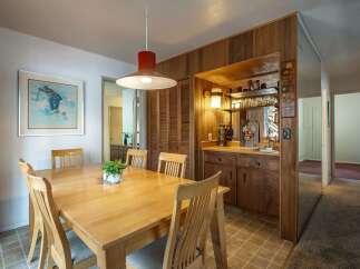 This dining area features a light wood table with four chairs, perfect for intimate meals.