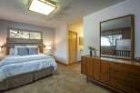 This charming bedroom features a comfortable queen-size bed with plush bedding and decorative pillows, perfect for a restful night's sleep.