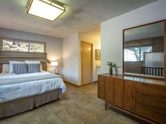 This charming bedroom features a comfortable queen-size bed with plush bedding and decorative pillows, perfect for a restful night's sleep.