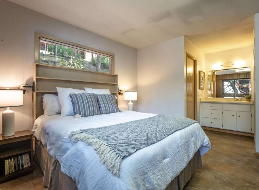 Discover comfort and style in this inviting bedroom, featuring a plush queen-size bed adorned with crisp white linens and decorative pillows.