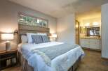 Discover comfort and style in this inviting bedroom, featuring a plush queen-size bed adorned with crisp white linens and decorative pillows.