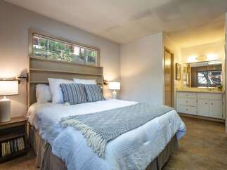 Discover comfort and style in this inviting bedroom, featuring a plush queen-size bed adorned with crisp white linens and decorative pillows.