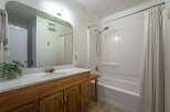 This bathroom features a spacious vanity with ample storage and a large mirror, perfect for your morning routine.