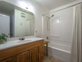 This bathroom features a spacious vanity with ample storage and a large mirror, perfect for your morning routine.