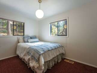 This charming bedroom offers a cozy retreat with its comfortable queen-size bed, adorned with blue and white striped bedding and plush pillows.