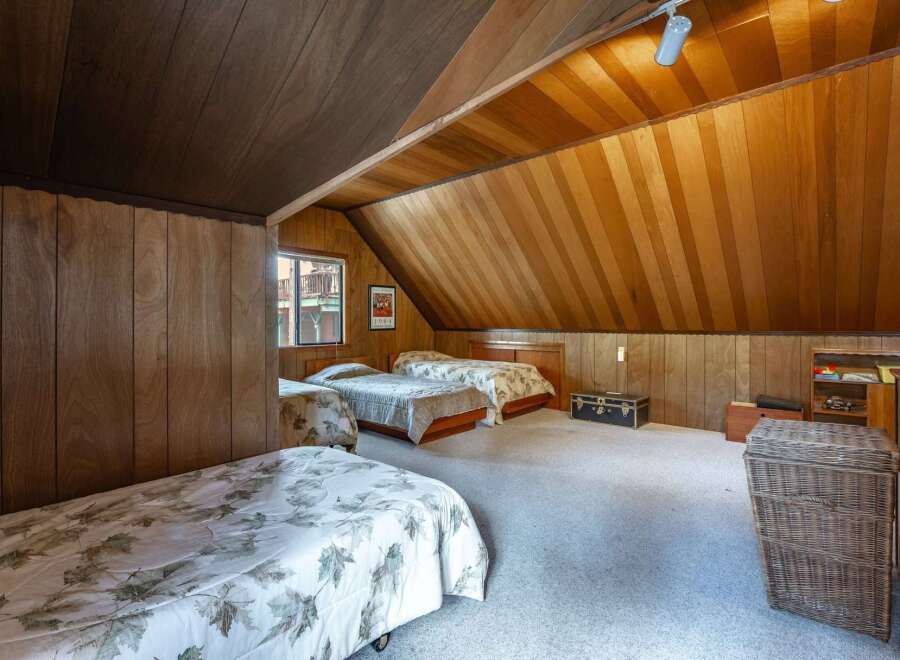 This charming attic bedroom features a cozy and rustic ambiance, perfect for a guest room or a unique living space.