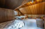 This charming attic bedroom features a cozy and rustic ambiance, perfect for a guest room or a unique living space.