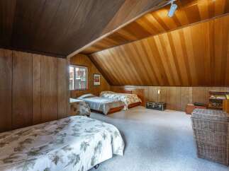This charming attic bedroom features a cozy and rustic ambiance, perfect for a guest room or a unique living space.