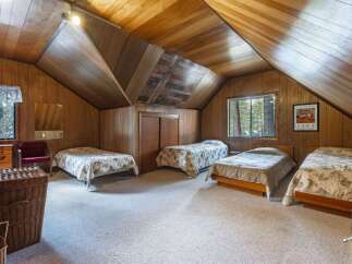 This charming attic bedroom features multiple beds, perfect for accommodating family and friends.