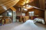 Discover this charming attic bedroom, featuring a cozy sleeping area and a dedicated workspace with a desk and chair.