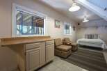This charming space features a convenient kitchenette area with ample counter space and cabinetry, perfect for preparing light meals.