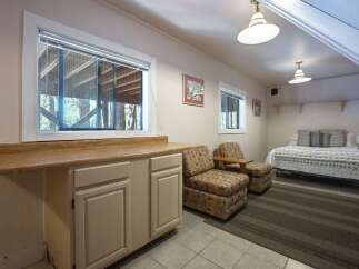 This charming space features a convenient kitchenette area with ample counter space and cabinetry, perfect for preparing light meals.