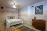 Discover this charming bedroom featuring a comfortable queen-size bed adorned with a decorative throw and plush pillows.