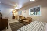 Discover this charming studio apartment featuring a compact kitchen area and a cozy living space with two accent chairs.