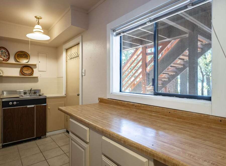Discover a charming kitchen space featuring a functional sink and ample countertop area, perfect for meal preparation.