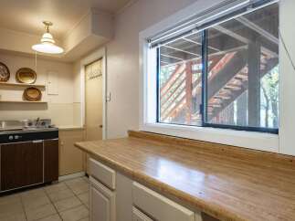 Discover a charming kitchen space featuring a functional sink and ample countertop area, perfect for meal preparation.